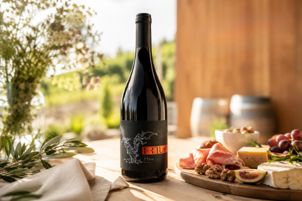 Fľaša červeného vína Hron značky Frtus Winery na prestretom stole